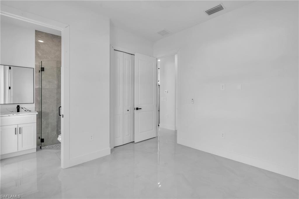 3110 23rd Street Southwest Lehigh Acres, FL 33976 - Photo 13 of 27 Unfurnished bedroom featuring connected bathroom and a closet