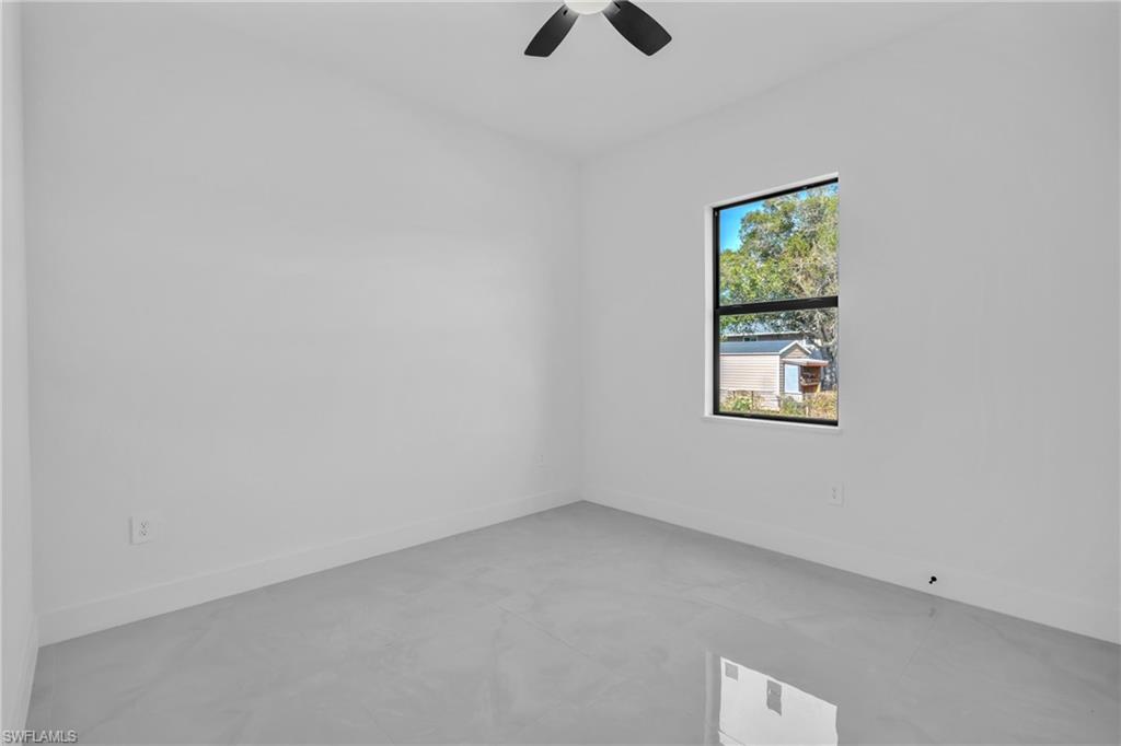 3110 23rd Street Southwest Lehigh Acres, FL 33976 - Photo 15 of 27 Unfurnished room with concrete flooring and ceiling fan