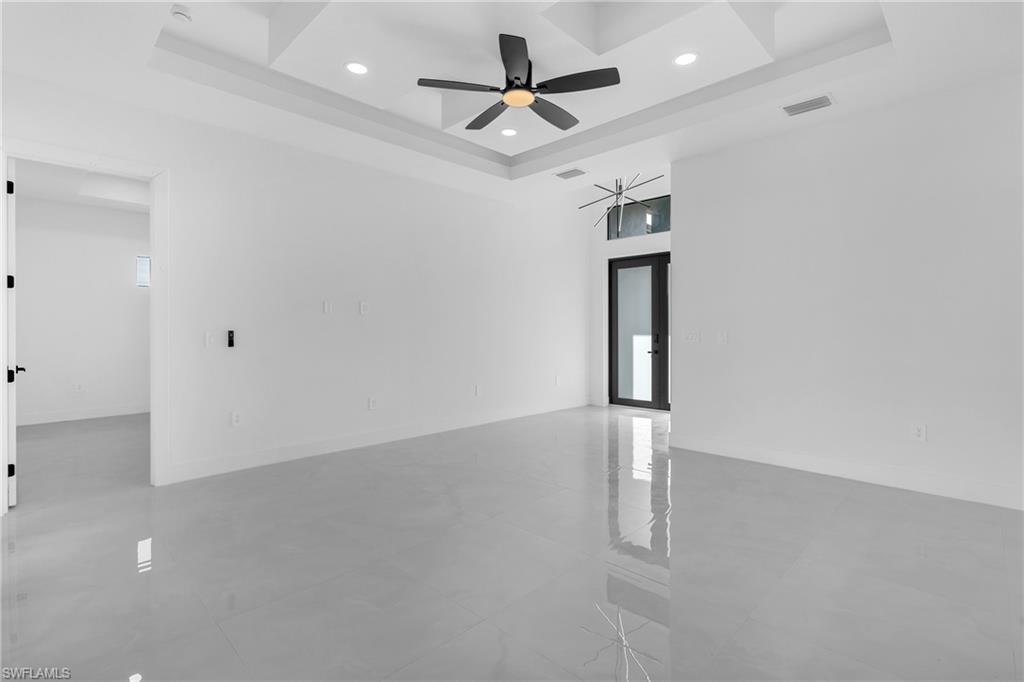 3110 23rd Street Southwest Lehigh Acres, FL 33976 - Photo 21 of 27 Spare room with a ceiling fan, french doors, recessed lighting, and a tray ceiling