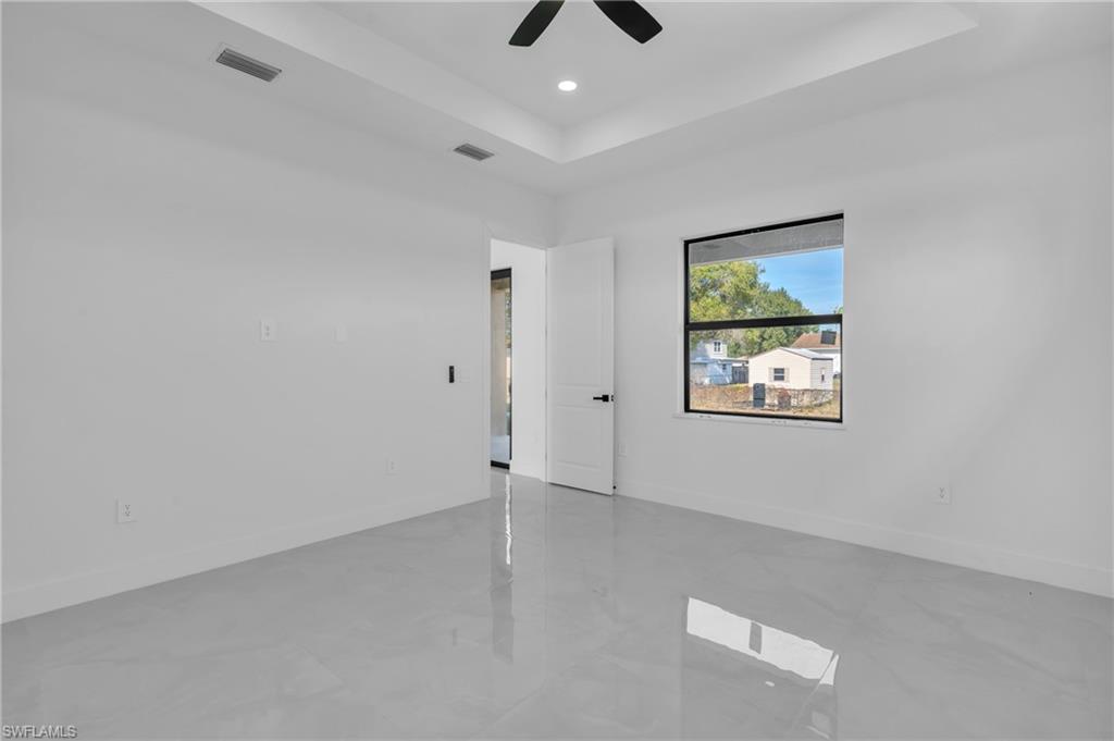 3110 23rd Street Southwest Lehigh Acres, FL 33976 - Photo 22 of 27 Empty room with a raised ceiling, ceiling fan, and recessed lighting