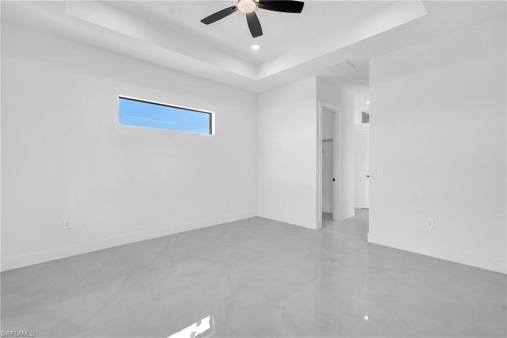 3110 23rd Street Southwest Lehigh Acres, FL 33976 - Photo 23 of 27 Empty room with a tray ceiling, concrete flooring, ceiling fan, and recessed lighting