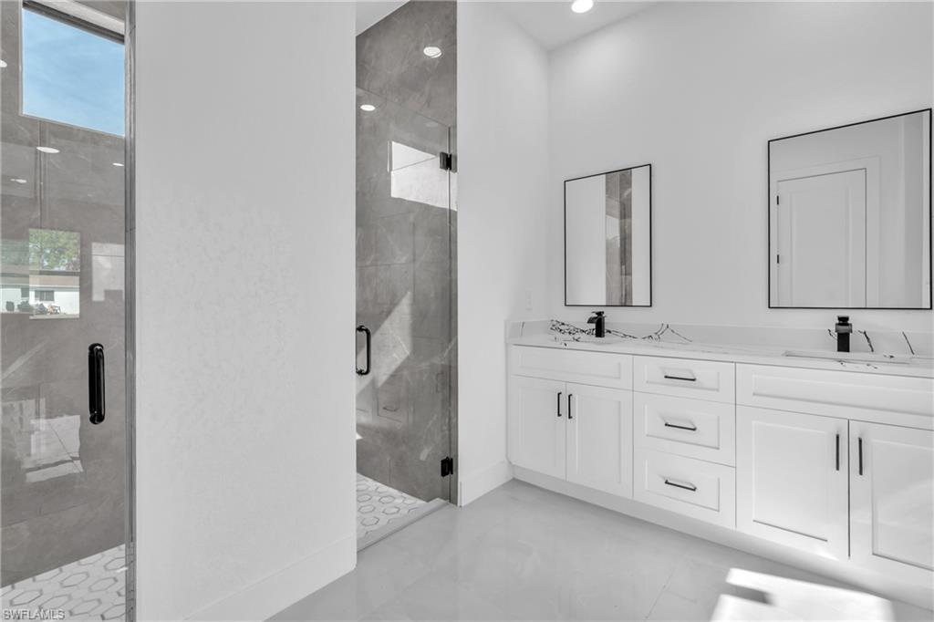 3110 23rd Street Southwest Lehigh Acres, FL 33976 - Photo 8 of 27 Full bathroom with a shower stall and double vanity