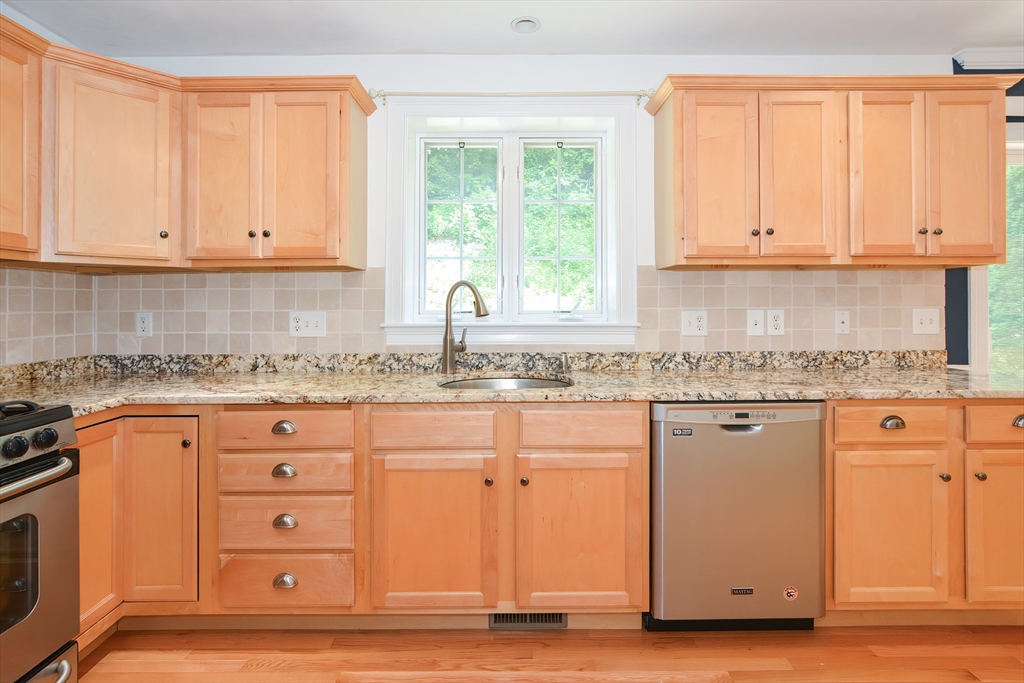 61 Providence Road, Unit 2 Grafton, MA 01519 - Photo 13 of 35 a kitchen with granite countertop a sink cabinets and a window