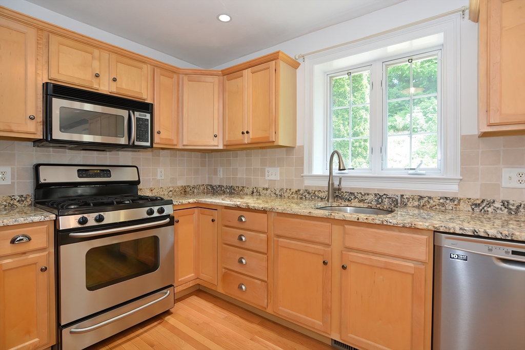 61 Providence Road, Unit 2 Grafton, MA 01519 - Photo 14 of 35 a kitchen with granite countertop white cabinets appliances and a window