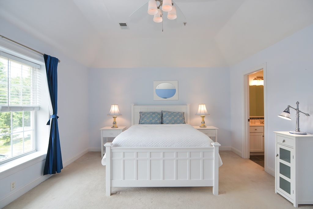 61 Providence Road, Unit 2 Grafton, MA 01519 - Photo 17 of 35 a bedroom with a bed a window and a chandelier