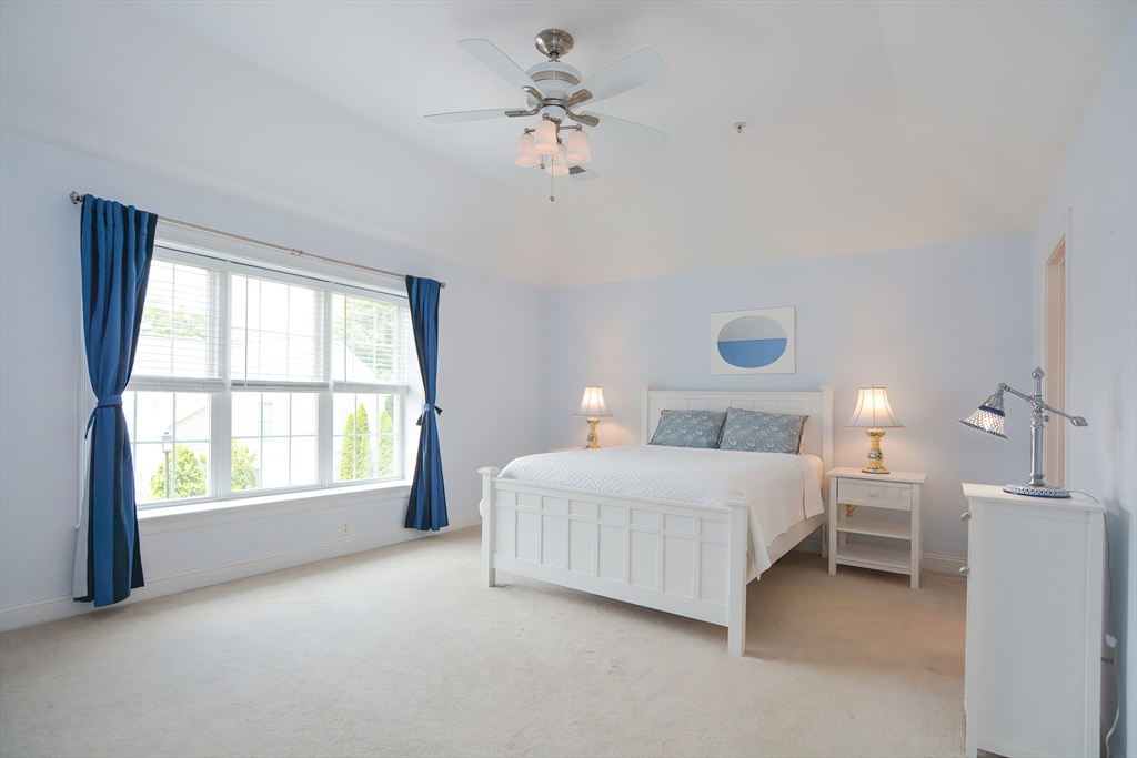 61 Providence Road, Unit 2 Grafton, MA 01519 - Photo 19 of 35 a spacious bedroom with a bed and a chandelier