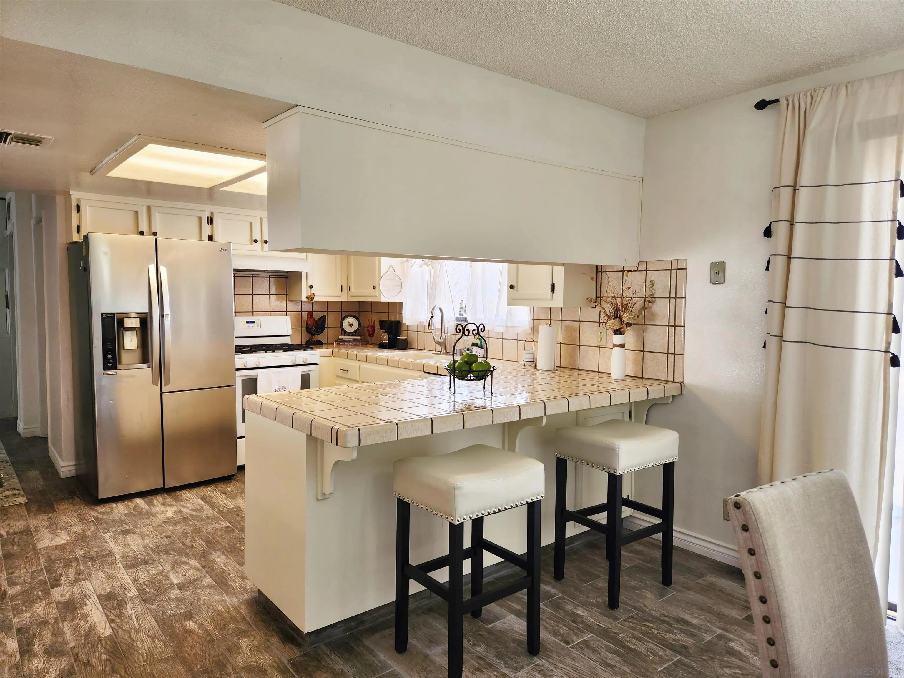 3628 Alene Avenue Ridgecrest, CA 93555 - Photo 13 of 46 a kitchen with stainless steel appliances a refrigerator a sink a stove a table and chairs