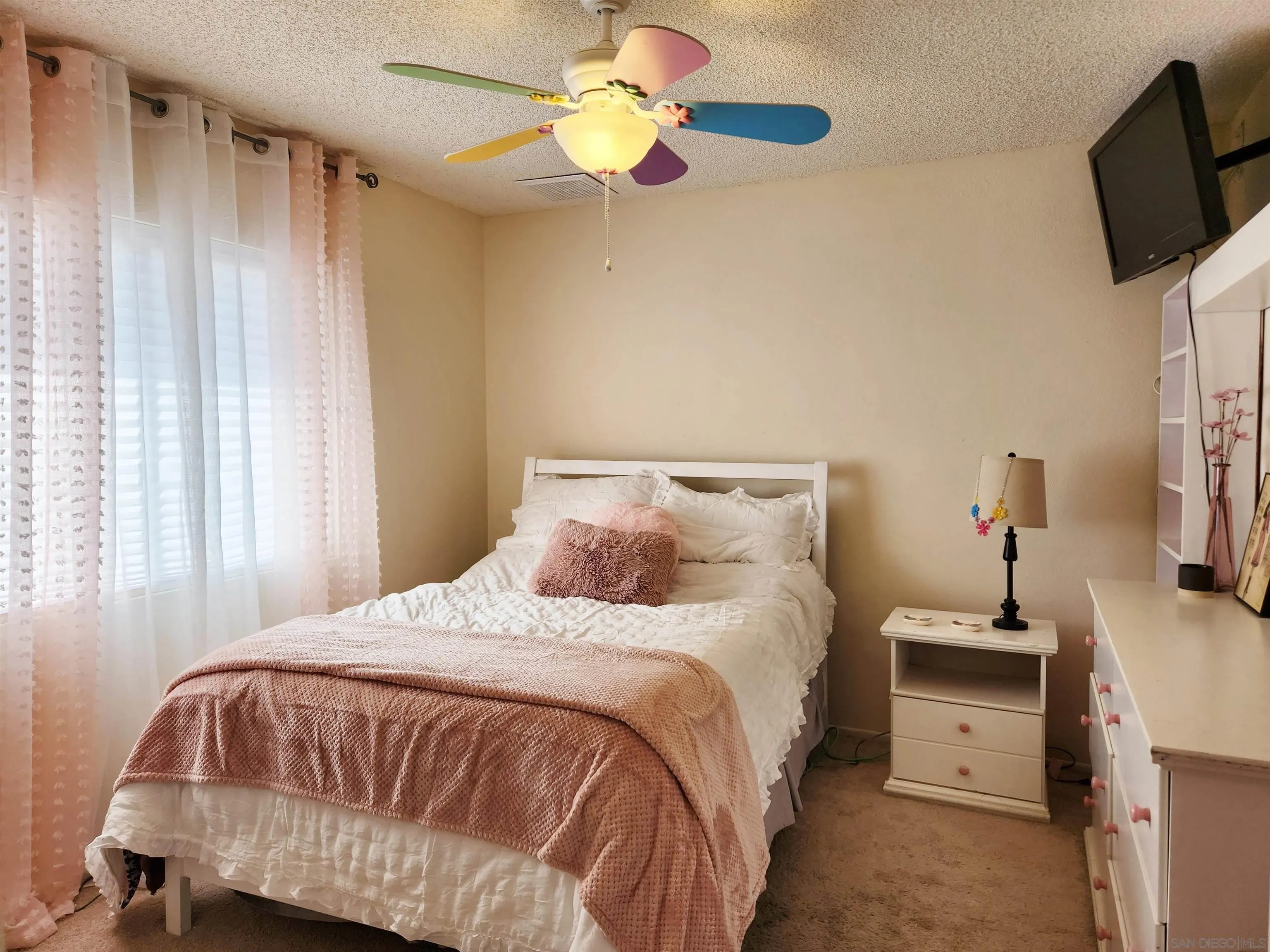3628 Alene Avenue Ridgecrest, CA 93555 - Photo 34 of 46 a bedroom with a bed a flat screen tv and a chandelier