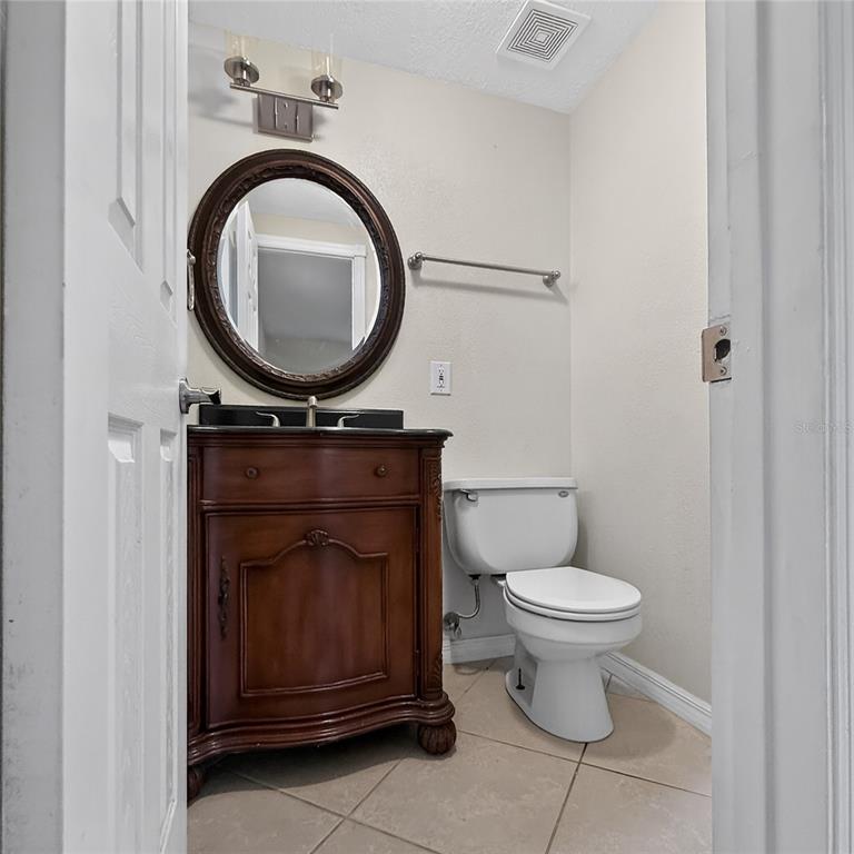 17220 Estes Road Lutz, FL 33548 - Photo 14 of 25 a bathroom with a toilet a sink and a mirror