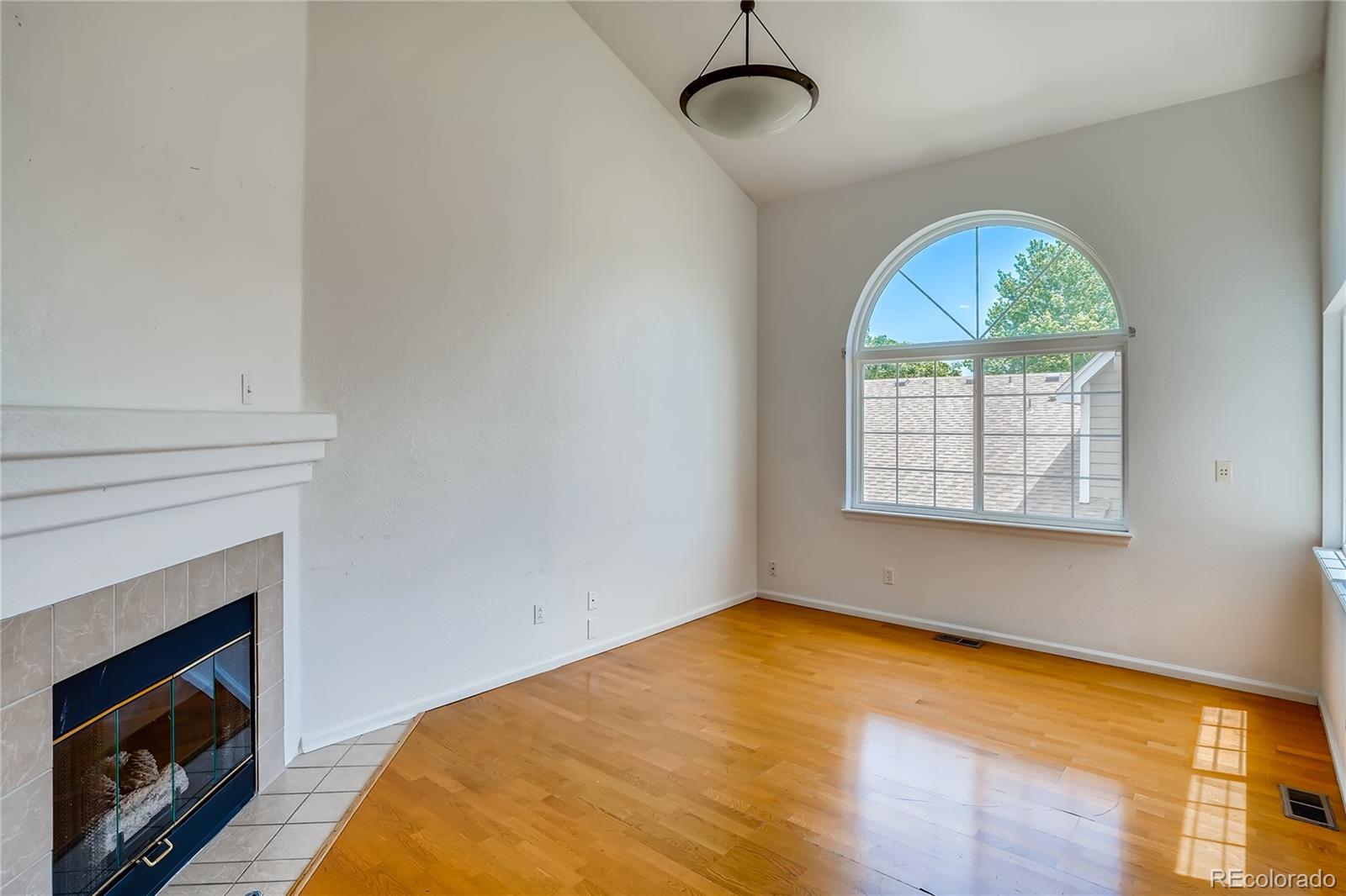 6778 Zenobia Loop, Unit 2 Westminster, CO 80030 - Photo 2 of 13 a bedroom with a bed and a fireplace