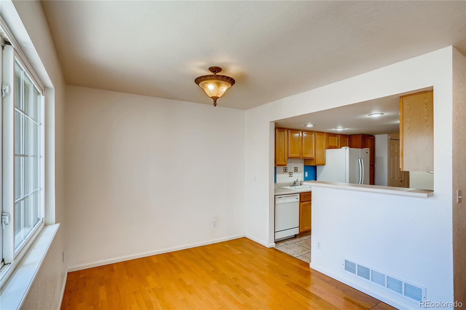 6778 Zenobia Loop, Unit 2 Westminster, CO 80030 - Photo 4 of 13 a view of a kitchen with wooden floor and a ceiling fan