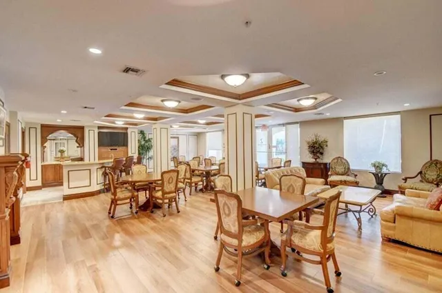 a living room with furniture a flat screen tv and a dining table