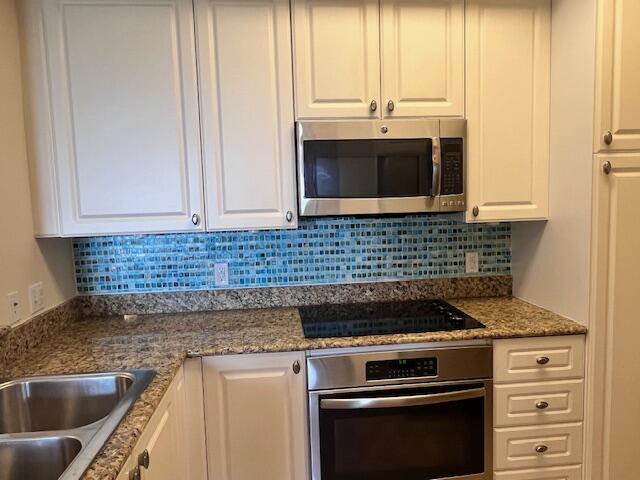 1660 Renaissance Commons Boulevard, Unit 2608 Boynton Beach, FL 33426 - Photo 6 of 31 a kitchen with granite countertop a sink stove and cabinets