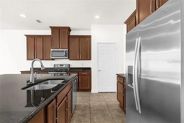 a kitchen with kitchen island stainless steel appliances cabinets a sink and a counter top space