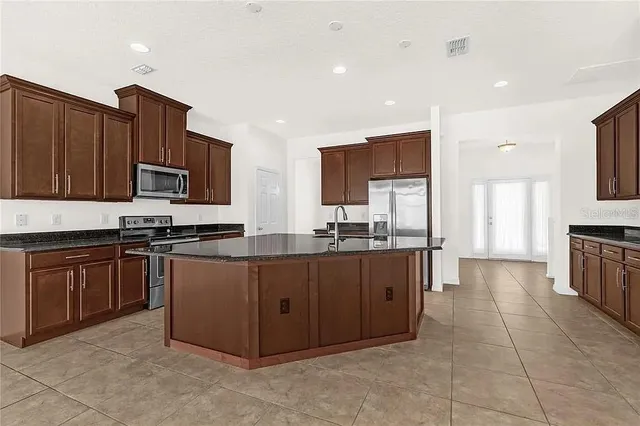 a large kitchen with stainless steel appliances lots of counter top space