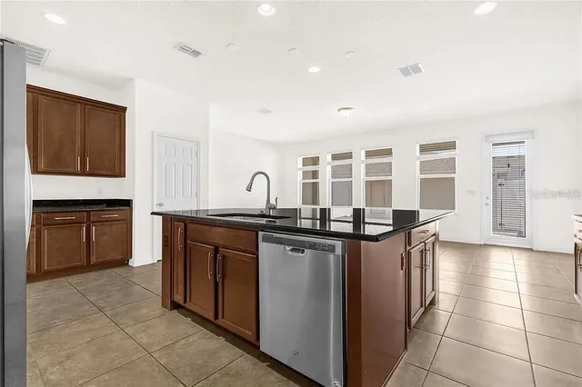 a kitchen with stainless steel appliances granite countertop a stove a sink and a refrigerator
