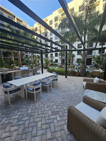 a view of a patio with couches and table and chairs with potted plants