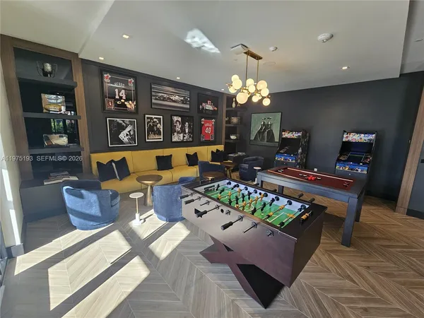 a living room with furniture a chandelier and pool table