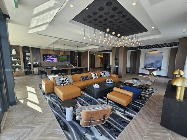 a living room with furniture a flat screen tv and kitchen view