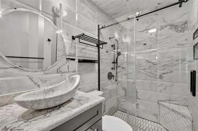 a bathroom with a granite countertop sink toilet and shower