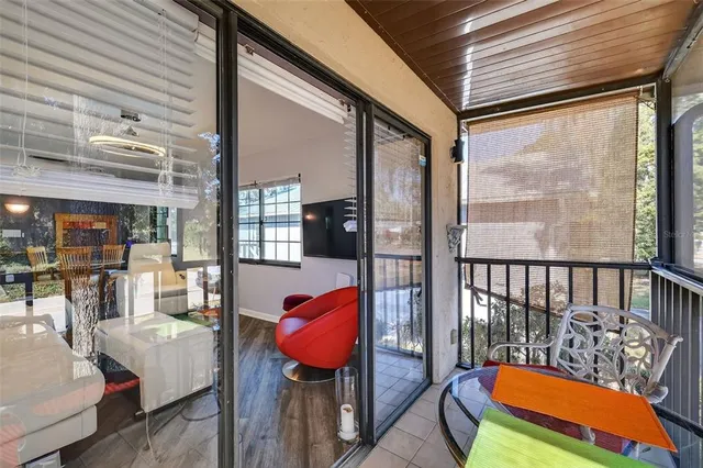 a balcony with chairs and a potted plant