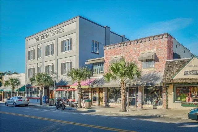 a view of a building with a street and car parked
