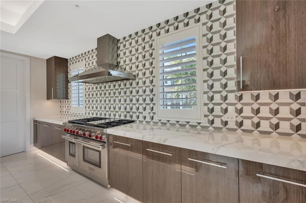 490 5th Street South, Unit 101 Naples, FL 34102 - Photo 16 of 50 a kitchen with granite countertop a sink and a stove