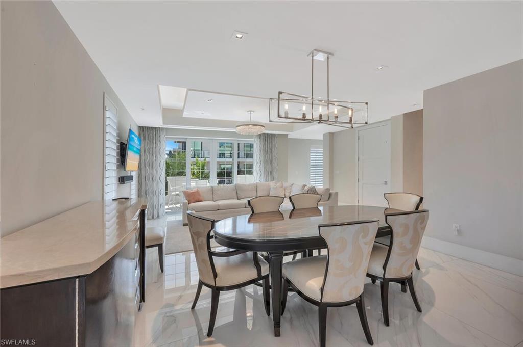 490 5th Street South, Unit 101 Naples, FL 34102 - Photo 19 of 50 a view of a dining room with furniture and chandelier