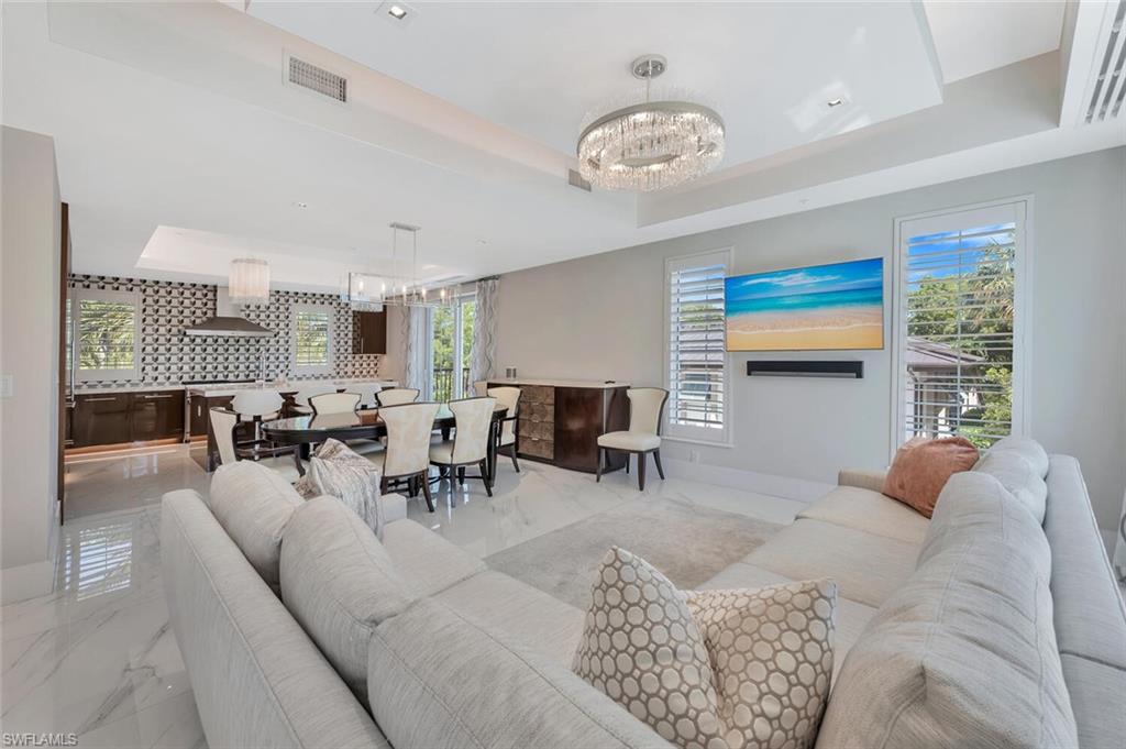 490 5th Street South, Unit 101 Naples, FL 34102 - Photo 22 of 50 a living room with furniture and a chandelier