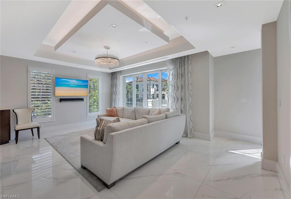 490 5th Street South, Unit 101 Naples, FL 34102 - Photo 24 of 50 a living room with furniture and a flat screen tv