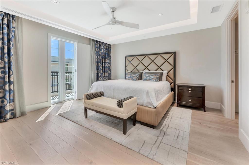 490 5th Street South, Unit 101 Naples, FL 34102 - Photo 29 of 50 a spacious bedroom with a bed and a couch