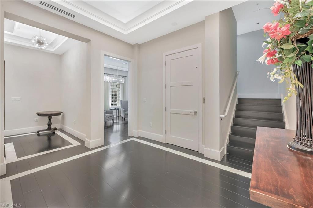 490 5th Street South, Unit 101 Naples, FL 34102 - Photo 3 of 50 a hallway with wooden floor and a potted plant