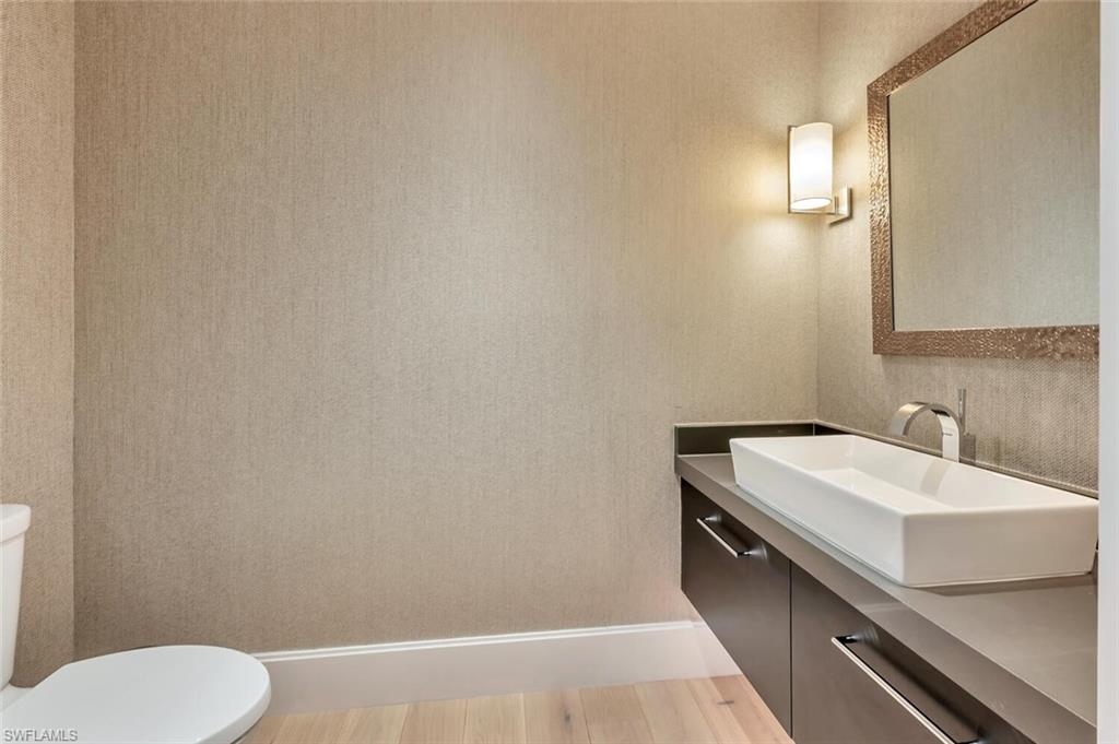 490 5th Street South, Unit 101 Naples, FL 34102 - Photo 33 of 50 a bathroom with a sink a toilet and mirror