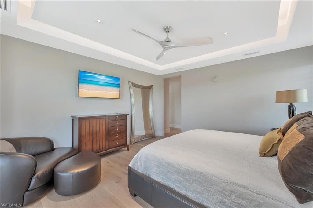 490 5th Street South, Unit 101 Naples, FL 34102 - Photo 35 of 50 a bedroom with a bed couch and a window