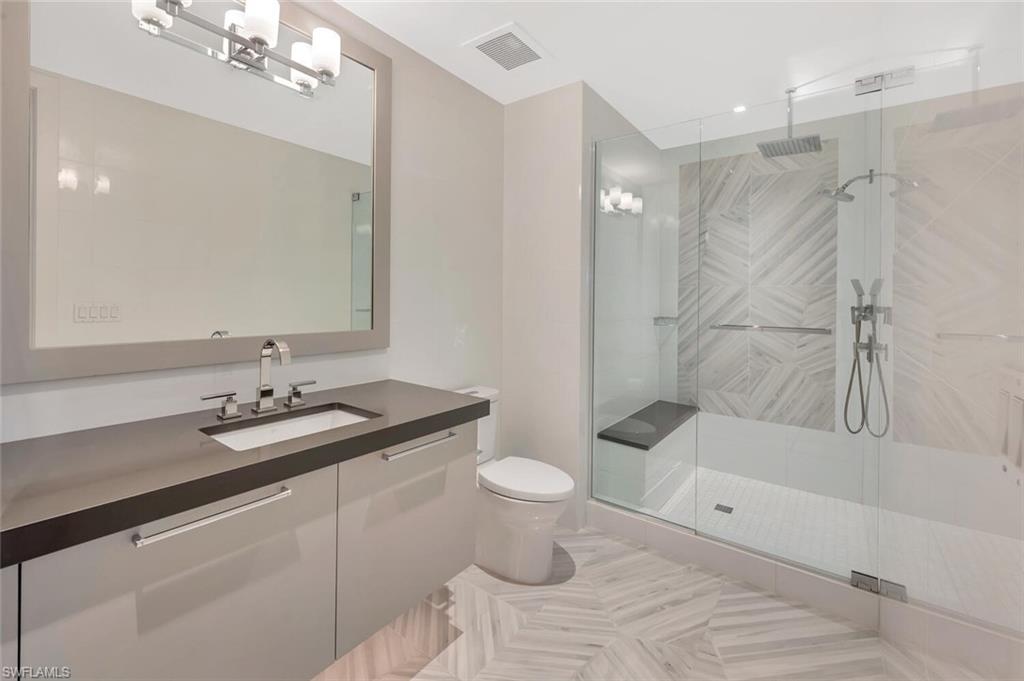 490 5th Street South, Unit 101 Naples, FL 34102 - Photo 36 of 50 a bathroom with a sink a toilet and shower