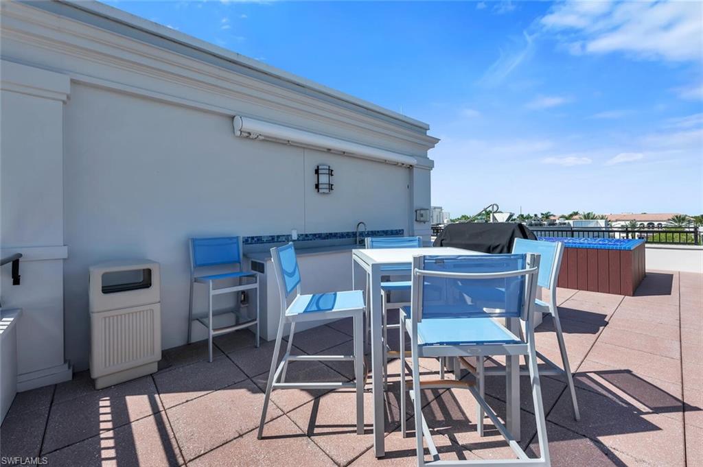 490 5th Street South, Unit 101 Naples, FL 34102 - Photo 46 of 50 a patio with table and chairs