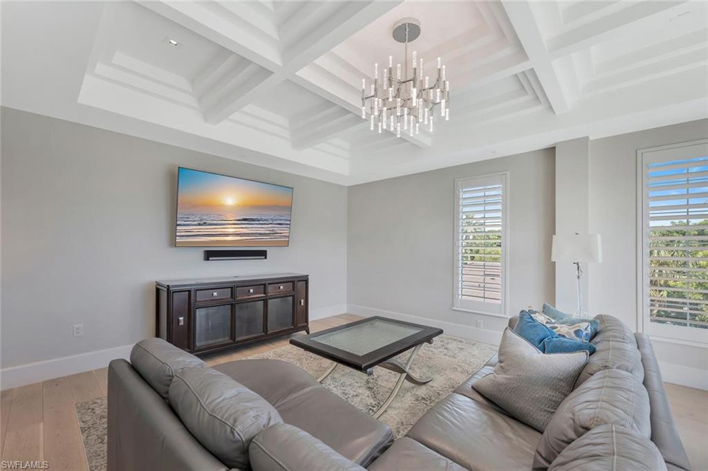 490 5th Street South, Unit 101 Naples, FL 34102 - Photo 6 of 50 a living room with furniture a chandelier and a window
