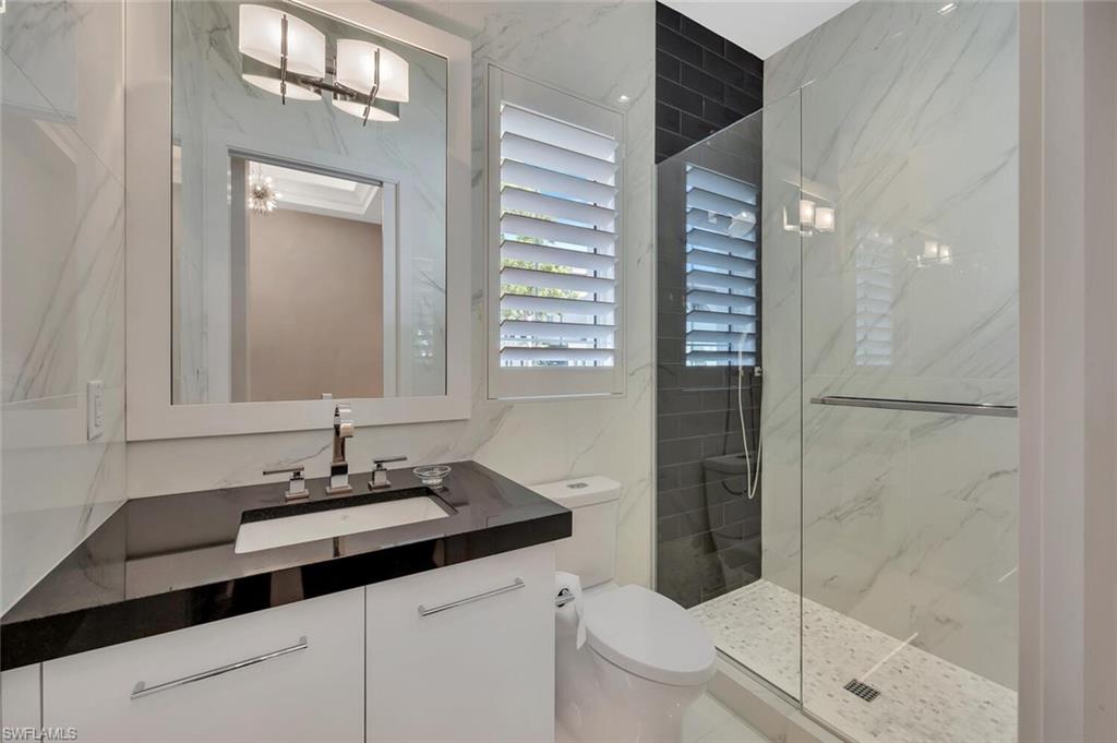 490 5th Street South, Unit 101 Naples, FL 34102 - Photo 9 of 50 a bathroom with a sink a toilet and shower