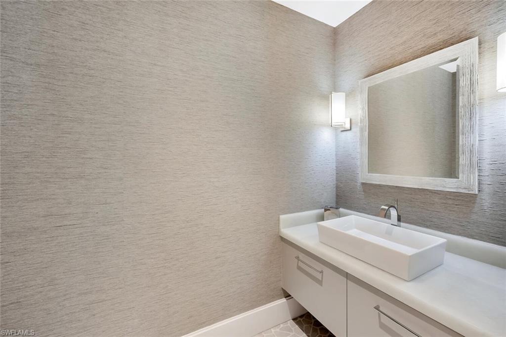 490 5th Street South, Unit 101 Naples, FL 34102 - Photo 10 of 50 a bathroom with a sink and a mirror