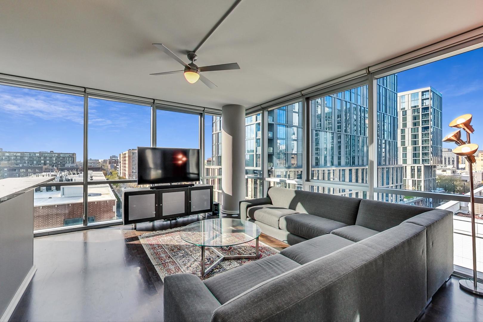 123 South Green Street, Unit 701B Chicago, IL 60607 - Photo 2 of 25 a living room with furniture a flat screen tv and a large window