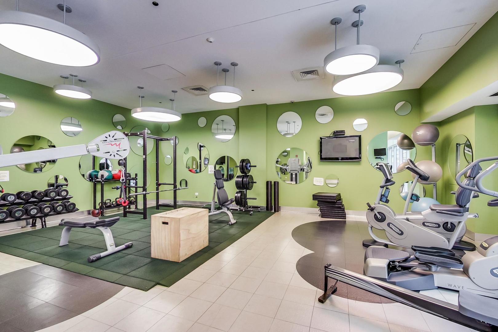 123 South Green Street, Unit 701B Chicago, IL 60607 - Photo 24 of 25 a room with lots of gym equipment and a chandelier