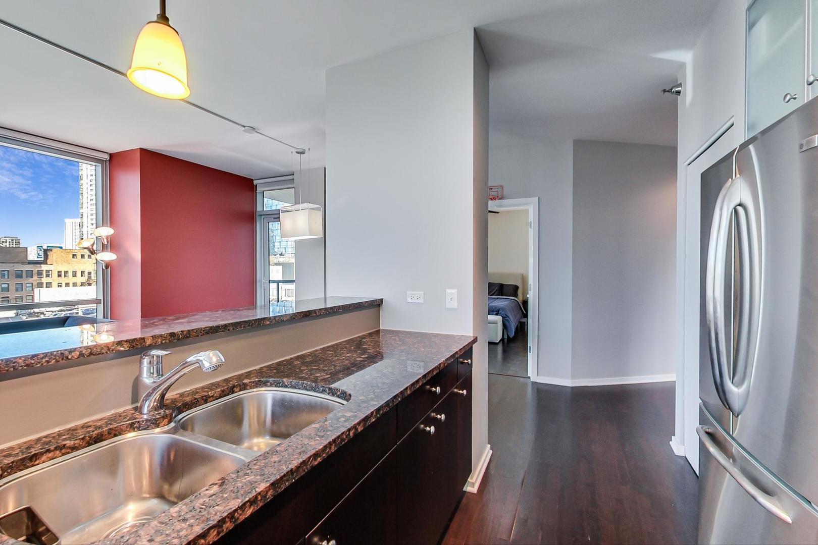123 South Green Street, Unit 701B Chicago, IL 60607 - Photo 7 of 25 a kitchen with stainless steel appliances granite countertop a sink stove and refrigerator