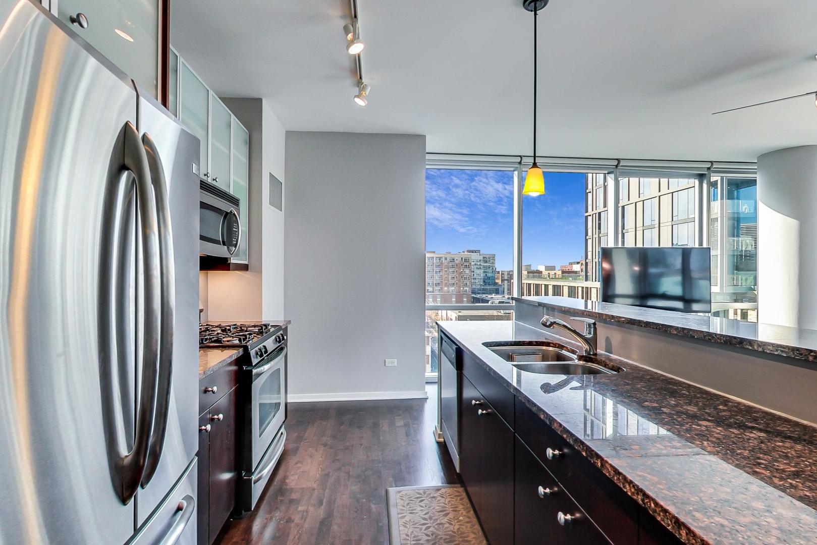 123 South Green Street, Unit 701B Chicago, IL 60607 - Photo 8 of 25 a kitchen with stainless steel appliances granite countertop a sink stove and refrigerator