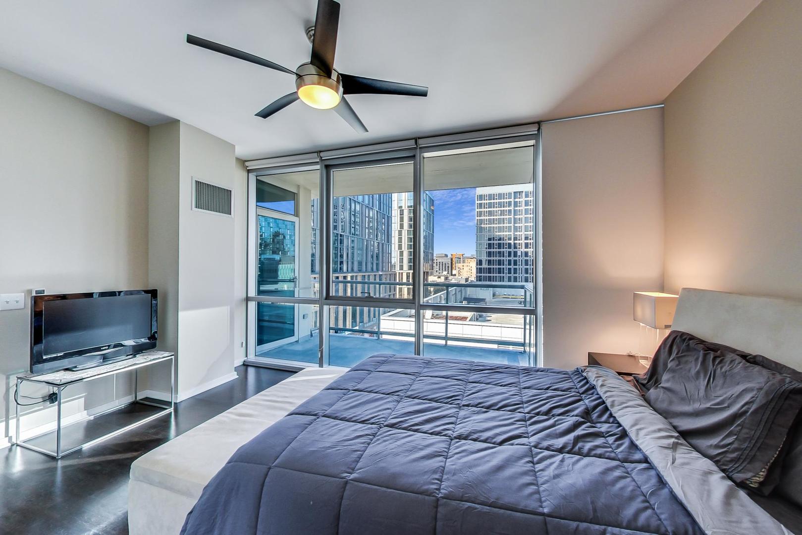 123 South Green Street, Unit 701B Chicago, IL 60607 - Photo 10 of 25 a bedroom with a bed and glass door