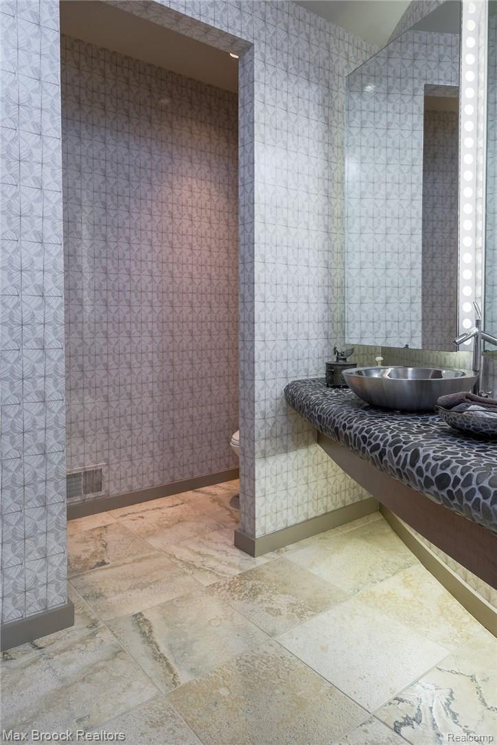 4455 Dow Ridge Road West Bloomfield, MI 48324 - Photo 18 of 50 Spectacular powder room with curved natural river rock counter and chrome vessel sink.
