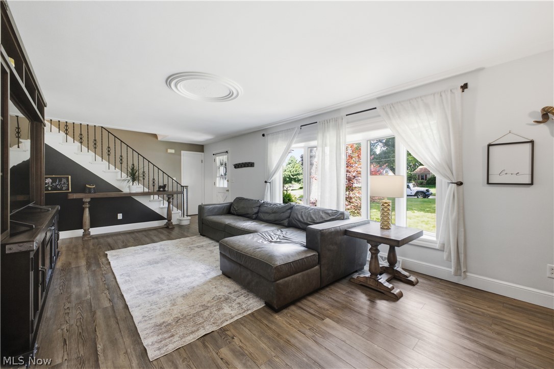 2411 Ridgeview Lane Youngstown, OH 44514 - Photo 6 of 48 Spacious living area featuring wood-finish flooring, a decorative ceiling medallion, and a prominent staircase with iron railings