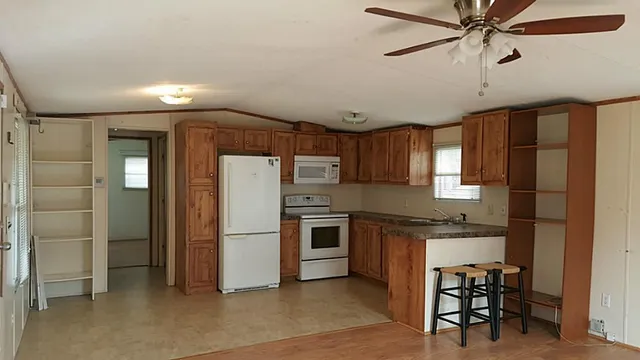 a kitchen with stainless steel appliances granite countertop a refrigerator and a stove top oven
