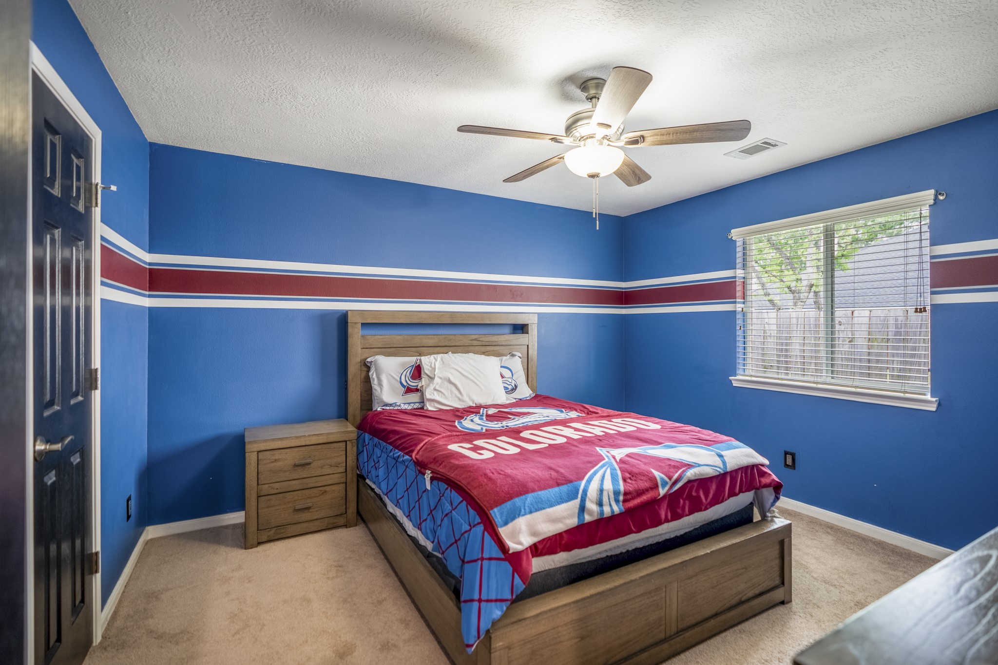 3411 Utah Beach Court Spring, TX 77388 - Photo 28 of 50 This secondary bedroom shines with a bold blue accent wall, ceiling fan, and natural light from the side-facing window. The closet sits just out of view, and the nearby hall keeps this room close to the shared full bath while still easy to reach from the main living areas.