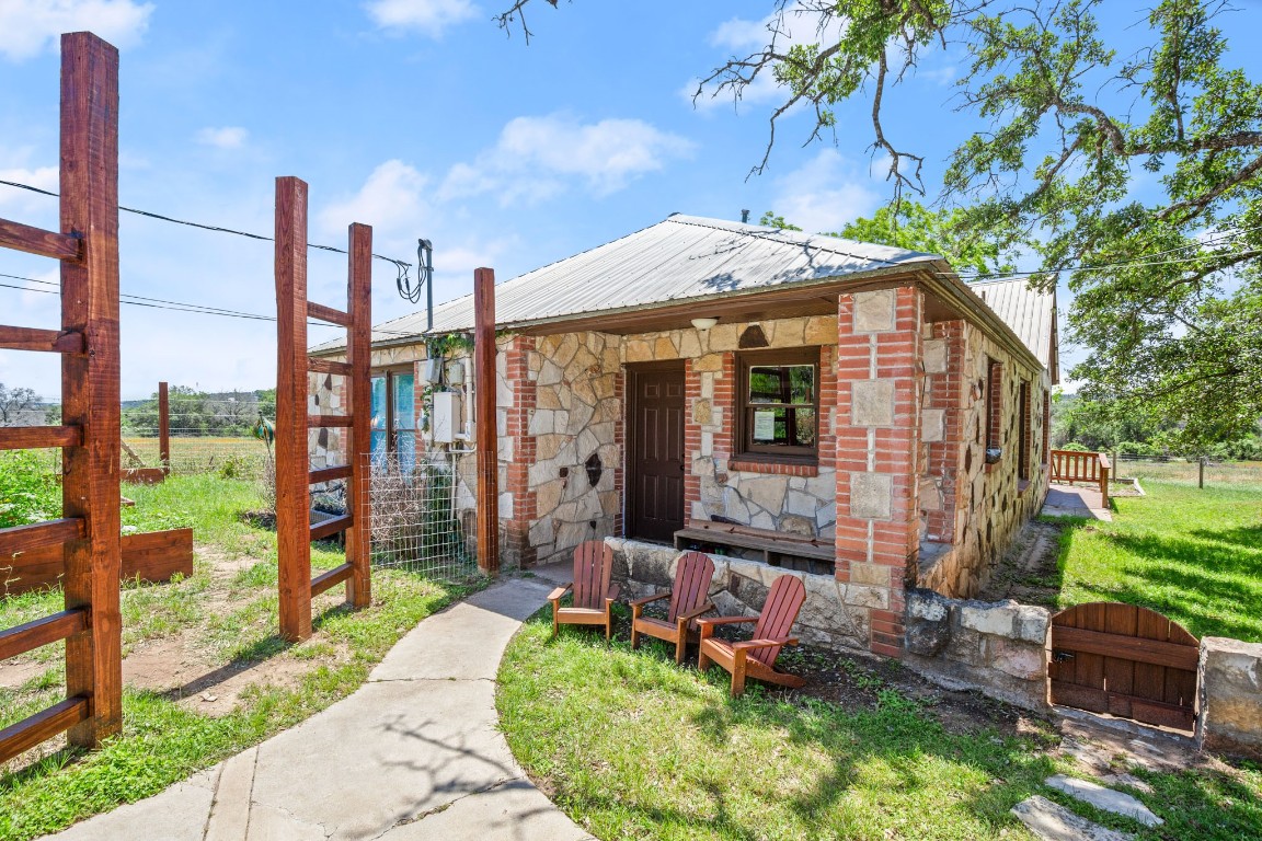 525 Pace Bend Road North Spicewood, TX 78669 - Photo 27 of 28 a front view of a house with a garden and plants