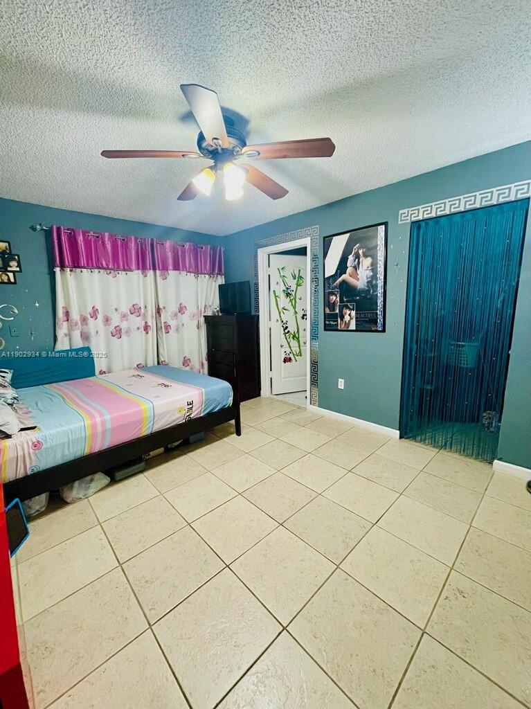 21316 Southwest 87th Place Cutler Bay, FL 33189 - Photo 4 of 14 a bedroom with a bed and a chandelier